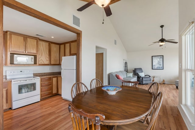 dining room with high vaulted ceiling, light wood-type flooring, visible vents, and a ceiling fan