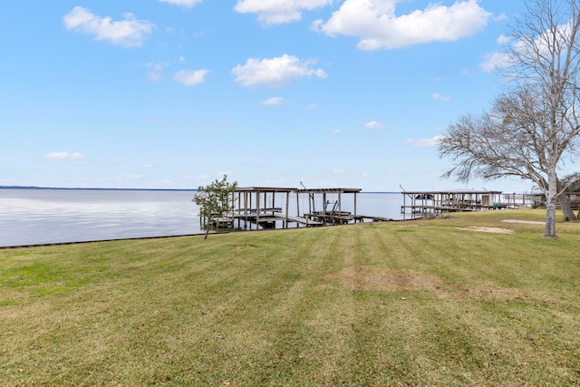 dock area with a lawn, a water view, and boat lift