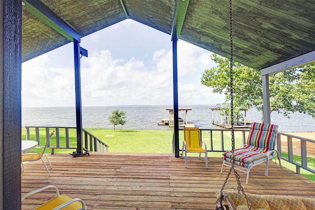 wooden deck featuring a water view and a lawn