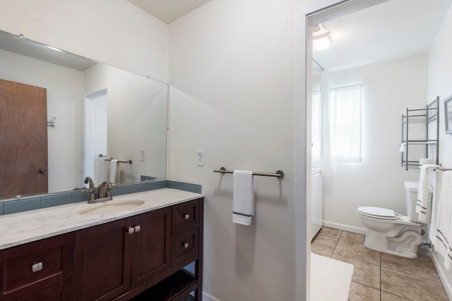 full bath featuring toilet, vanity, baseboards, and tile patterned floors