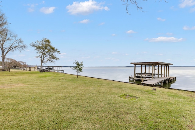 view of dock with a yard, a water view, and boat lift