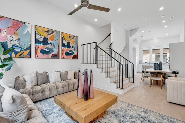 living room with light wood-style floors, stairs, a ceiling fan, and recessed lighting