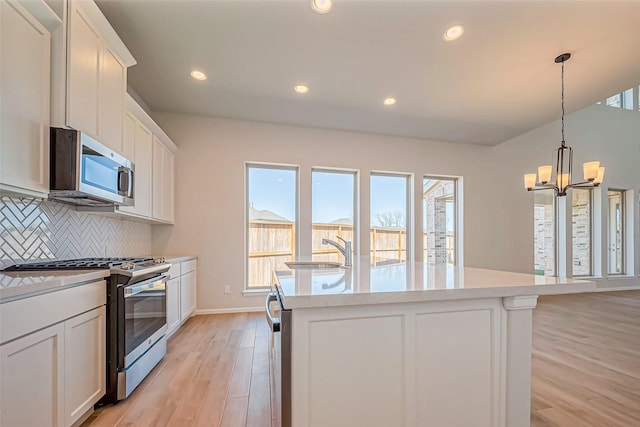 4046 Colony Ln, Missouri City, TX 77459 - kitchen featuring tasteful backsplash, light wood-type flooring, a sink, stainless steel appliances, and an island with sink