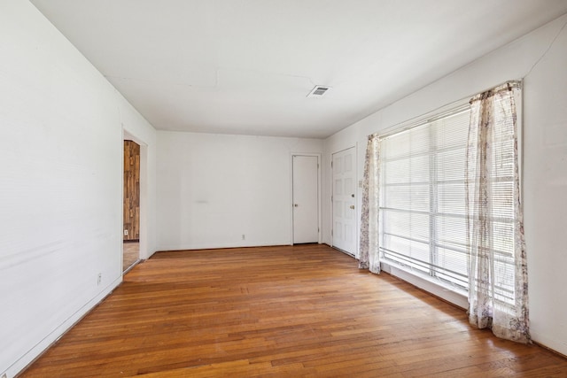 spare room with wood-type flooring and visible vents