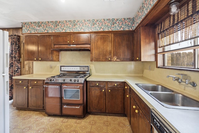 kitchen featuring dishwasher, light countertops, under cabinet range hood, double oven range, and a sink