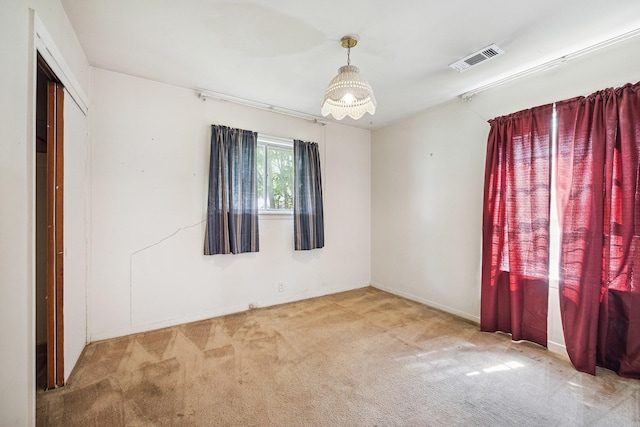 carpeted spare room with visible vents