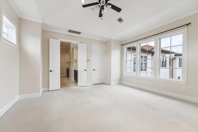 unfurnished bedroom featuring lofted ceiling, carpet, visible vents, and crown molding