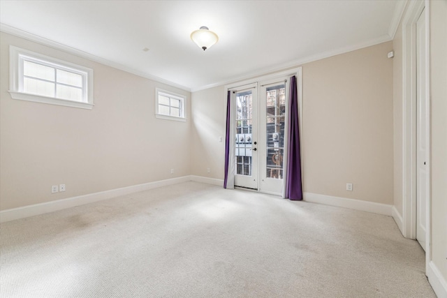 empty room featuring carpet flooring, french doors, baseboards, and ornamental molding