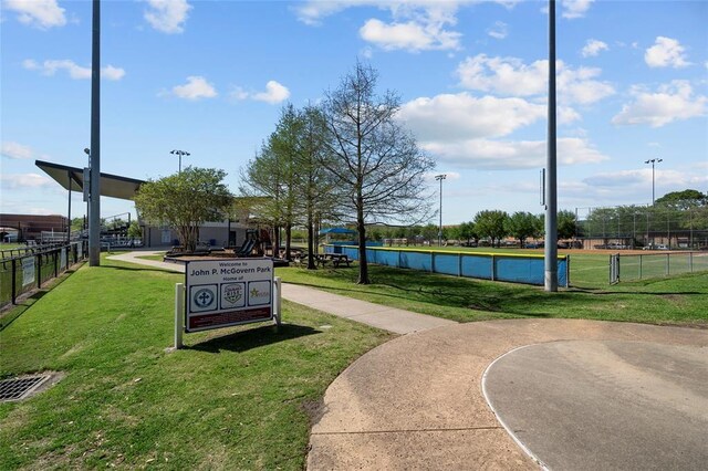 view of property's community with a lawn and fence