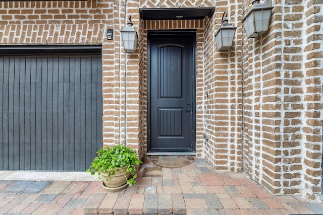 view of exterior entry featuring brick siding