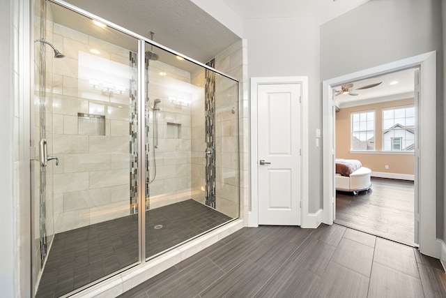 ensuite bathroom with a shower stall, baseboards, connected bathroom, and wood finish floors