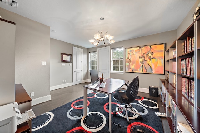 home office with a chandelier, visible vents, baseboards, and wood finished floors