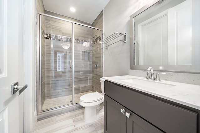 bathroom with toilet, a stall shower, visible vents, and vanity