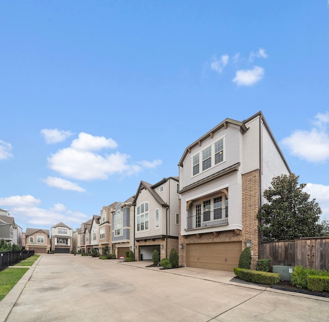 view of front of property with brick siding, stucco siding, a garage, a residential view, and driveway