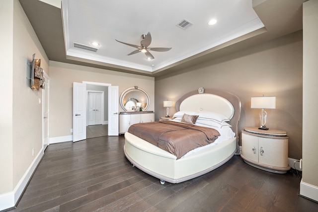 bedroom featuring visible vents, a raised ceiling, and wood finished floors