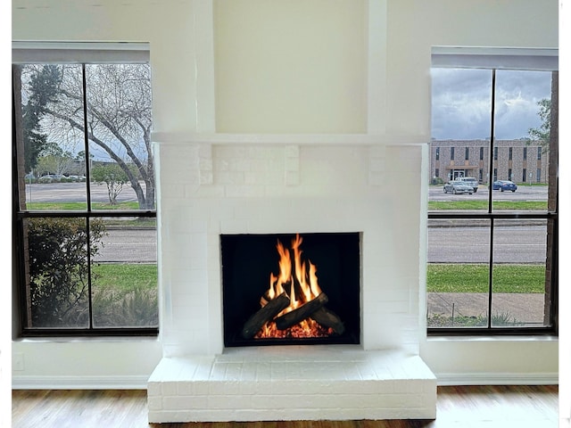 details with a brick fireplace, wood finished floors, and baseboards