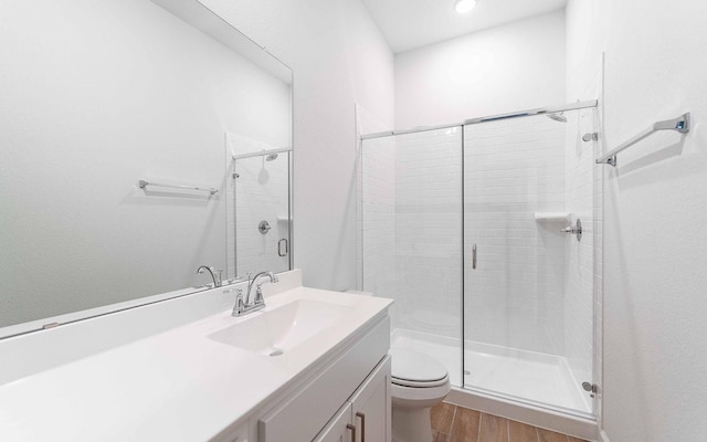 full bath featuring toilet, a shower stall, wood finished floors, and vanity