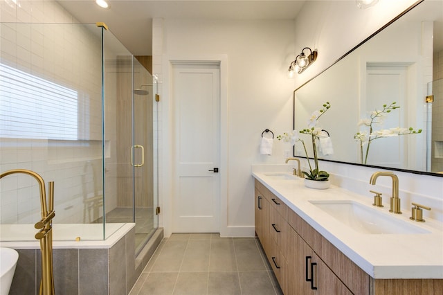 bathroom featuring double vanity, a stall shower, a sink, and tile patterned floors