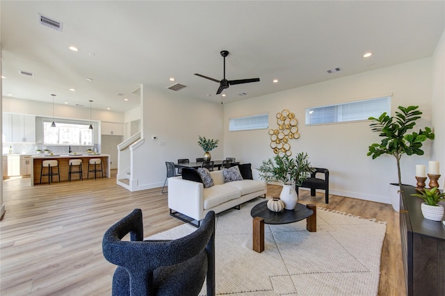 living area featuring light wood finished floors, baseboards, visible vents, and recessed lighting