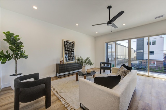 living room with light wood-style floors, recessed lighting, visible vents, and baseboards