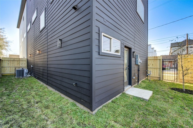 view of home's exterior featuring a yard, fence, and central air condition unit