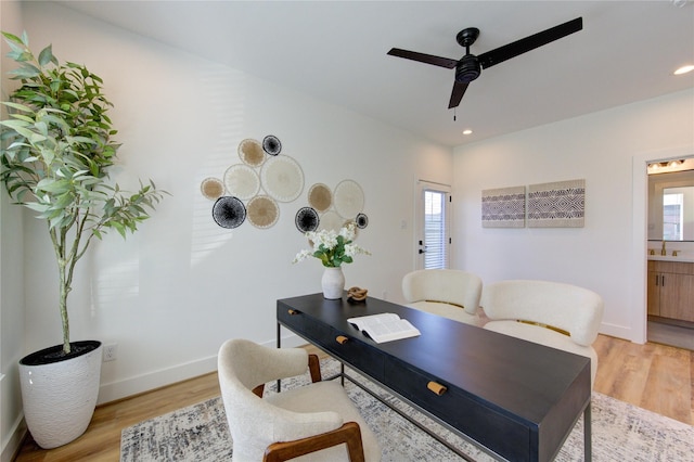 office space featuring a sink, light wood-style floors, baseboards, and a wealth of natural light