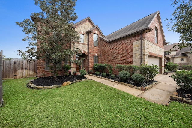 traditional-style home with an attached garage, brick siding, fence, stone siding, and a front yard