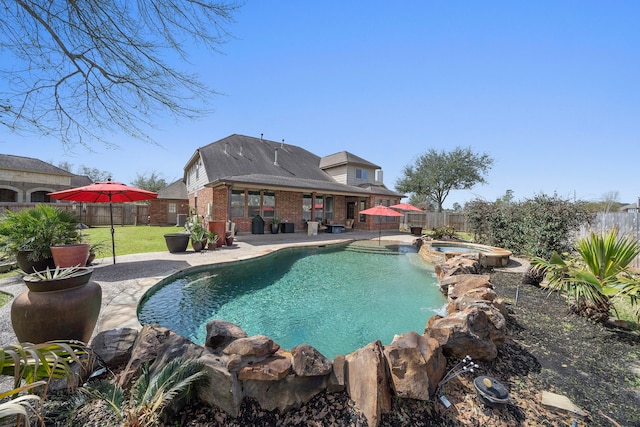 view of swimming pool featuring a yard, a patio area, a fenced backyard, and a pool with connected hot tub