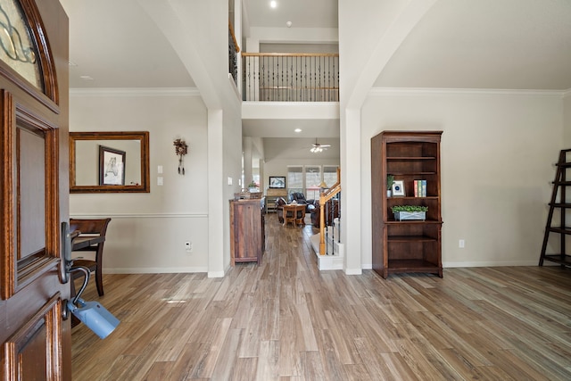 entrance foyer featuring ornamental molding, wood finished floors, and baseboards