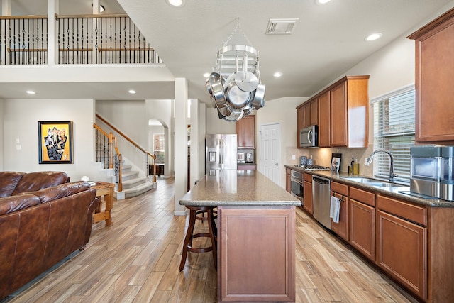 kitchen with visible vents, light wood-style flooring, appliances with stainless steel finishes, open floor plan, and a sink