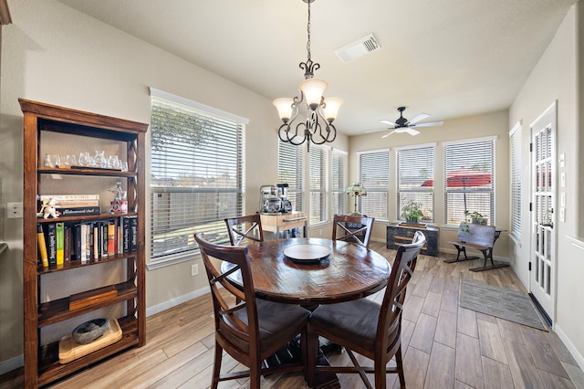 dining area with visible vents, light wood-style flooring, baseboards, and ceiling fan with notable chandelier