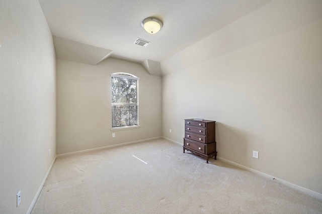 carpeted empty room with visible vents, a textured ceiling, and baseboards