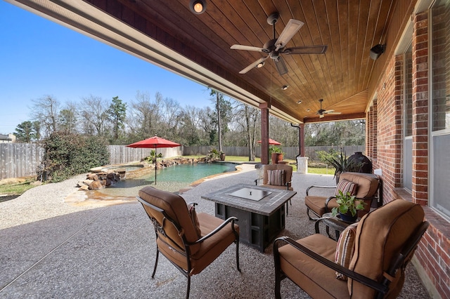 view of patio featuring ceiling fan, a fenced backyard, and a pool with connected hot tub