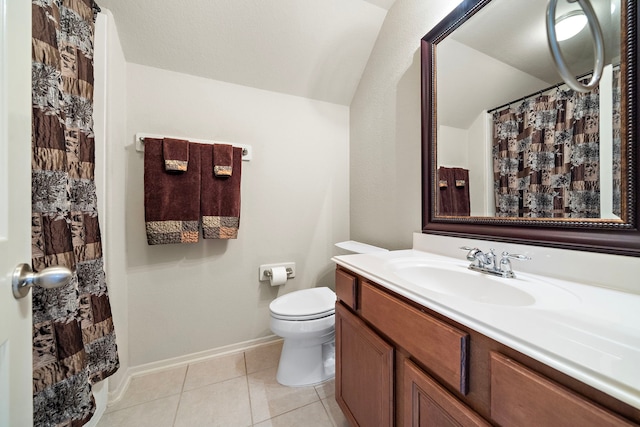 bathroom featuring toilet, vanity, baseboards, vaulted ceiling, and tile patterned floors