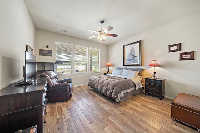 bedroom featuring light wood-style flooring, visible vents, ceiling fan, and baseboards