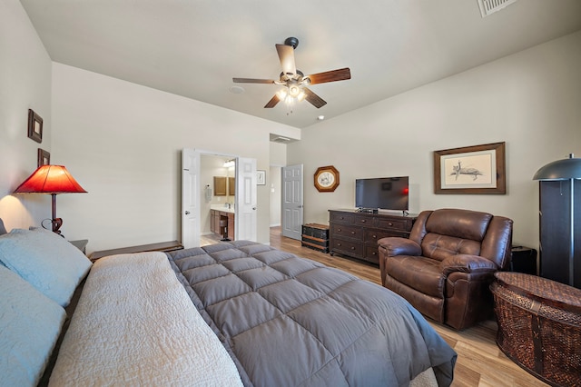 bedroom with light wood finished floors, a ceiling fan, visible vents, and connected bathroom