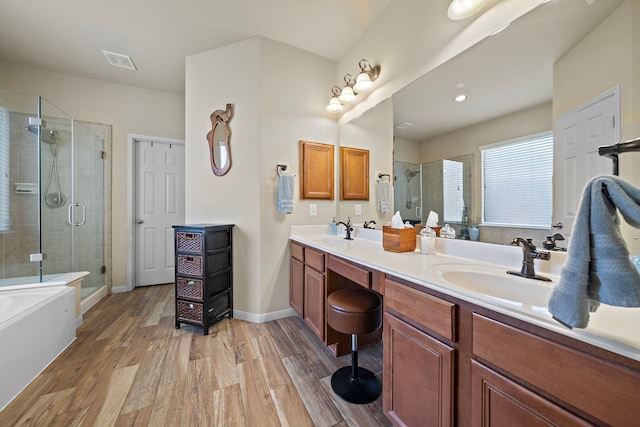 full bath with a garden tub, double vanity, visible vents, a stall shower, and wood finished floors