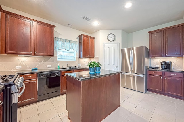 kitchen with a center island, light tile patterned floors, stainless steel appliances, visible vents, and dark stone countertops