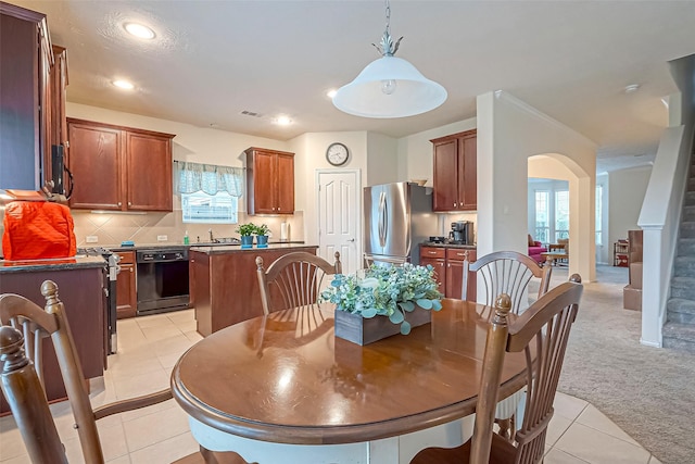 dining room featuring arched walkways, light carpet, stairway, and light tile patterned floors