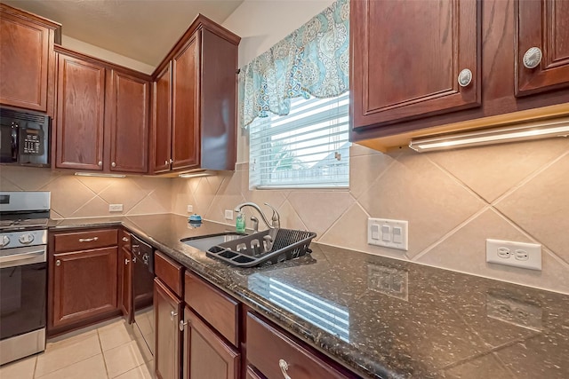 kitchen featuring light tile patterned floors, decorative backsplash, a sink, dark stone countertops, and black appliances