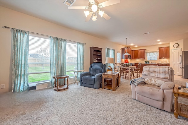 living room featuring light carpet, recessed lighting, visible vents, and a ceiling fan