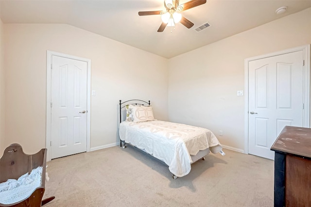 bedroom featuring light carpet, baseboards, visible vents, and lofted ceiling