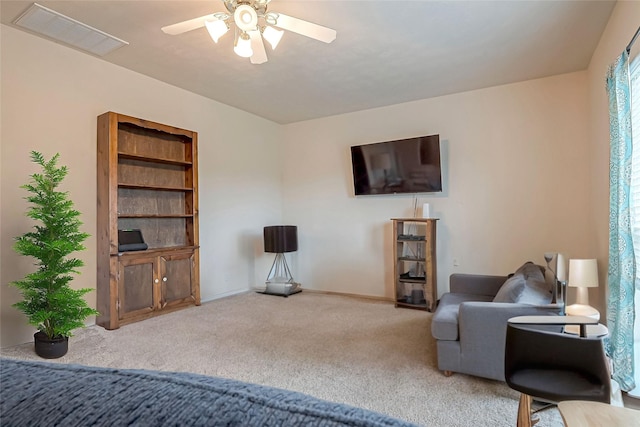 living room featuring ceiling fan, carpet, visible vents, and baseboards