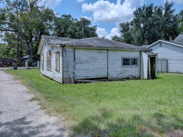 view of home's exterior with a yard and fence