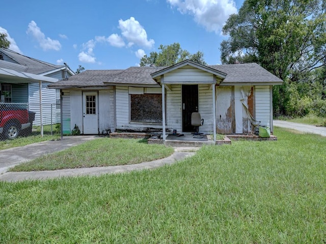 ranch-style home with roof with shingles and a front yard