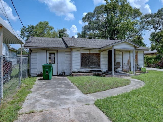 view of front facade featuring a front lawn and fence