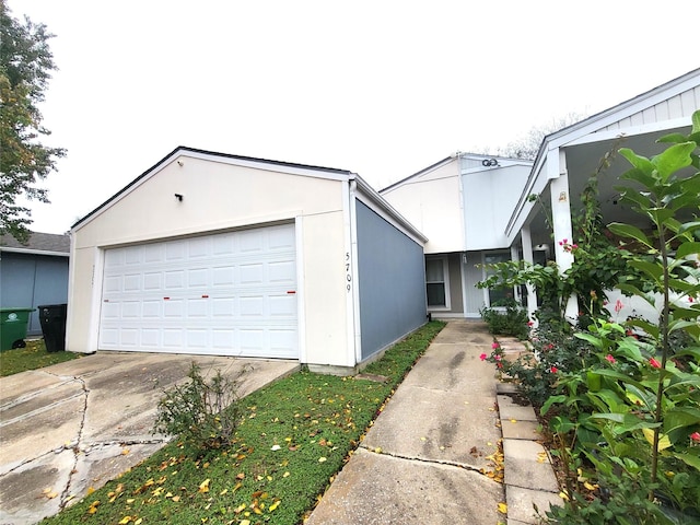 view of front facade featuring a detached garage and stucco siding