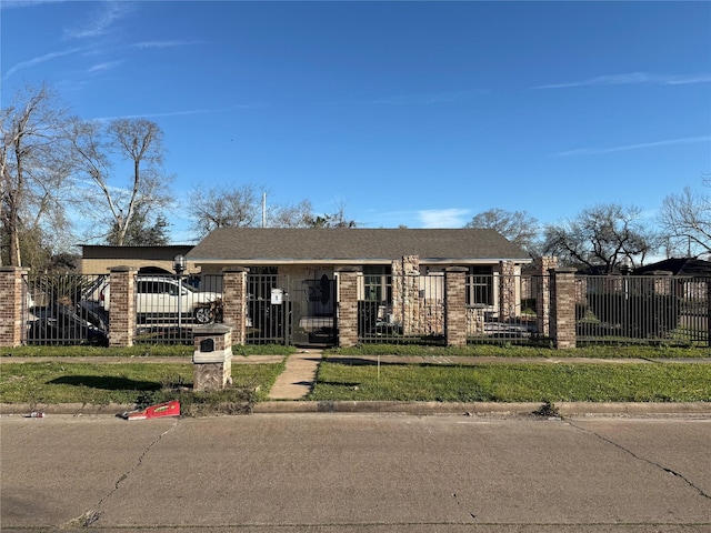 view of front of property featuring a fenced front yard, a gate, brick siding, and roof with shingles