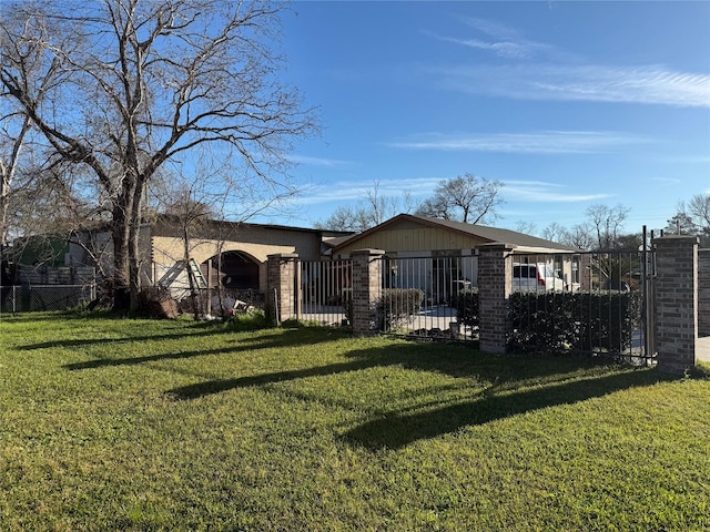 back of property with a yard, a fenced front yard, and brick siding