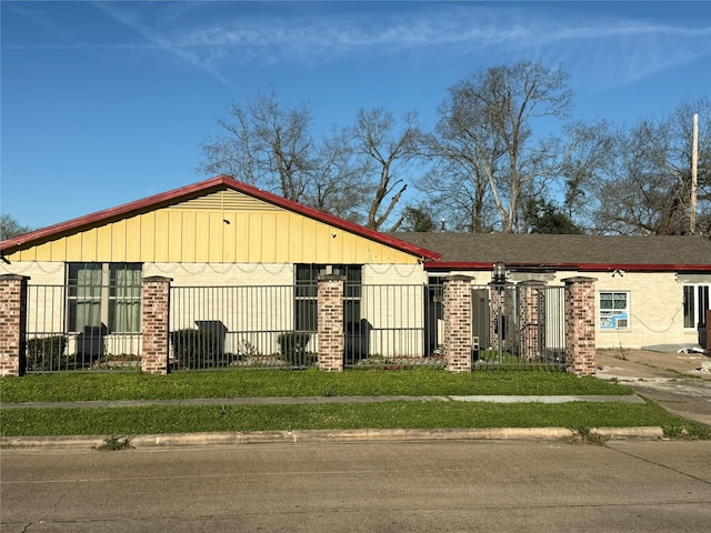 view of front of property with a fenced front yard and brick siding